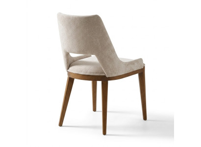 Ein lakonischer, moderner Stuhl mit hohen Beinen aus Holz und Polsterung in einer angenehmen, hellen cremefarbenen Farbe für das Esszimmer